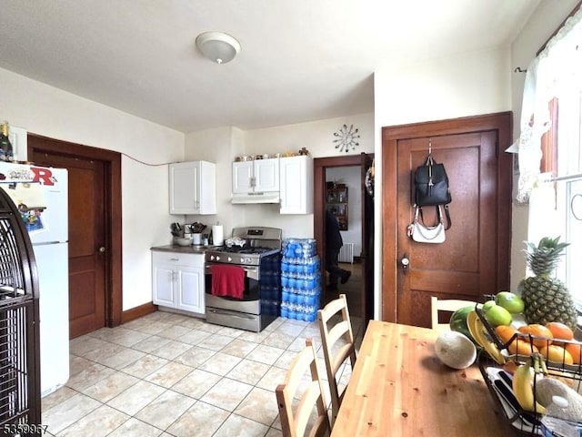 307 W Union Ave, Bound Brook Boro, NJ 08805 - kitchen featuring stainless steel range with gas stovetop, freestanding refrigerator, under cabinet range hood, white cabinetry, and light tile patterned flooring