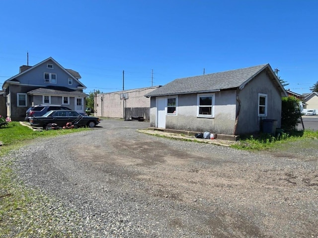 307 W Union Ave, Bound Brook Boro, NJ 08805 - view of front of house with stucco siding, a shingled roof, and driveway