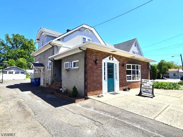307 W Union Ave, Bound Brook Boro, NJ 08805 - view of front of home featuring brick siding, an outbuilding, and stucco siding