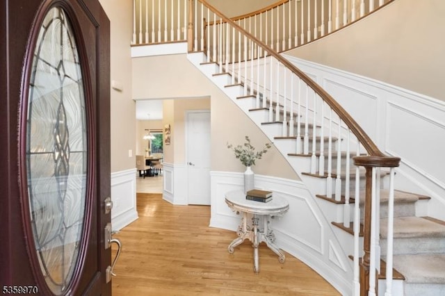 9 Oakridge Rd, Clinton Twp, NJ 08801 - entrance foyer featuring wainscoting, a decorative wall, stairs, wood finished floors, and a high ceiling