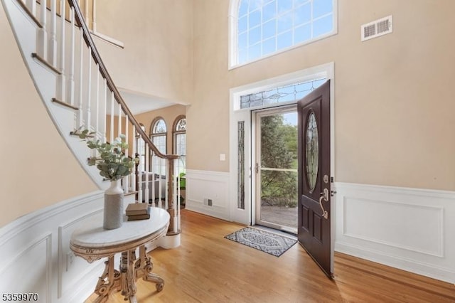 9 Oakridge Rd, Clinton Twp, NJ 08801 - foyer entrance featuring wainscoting, stairs, a decorative wall, wood finished floors, and a high ceiling