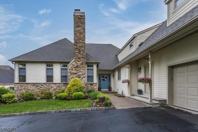 22 Troon Dr, Fredon Twp, NJ 07860 - view of front of home with a chimney, roof with shingles, stone siding, a garage, and asphalt driveway