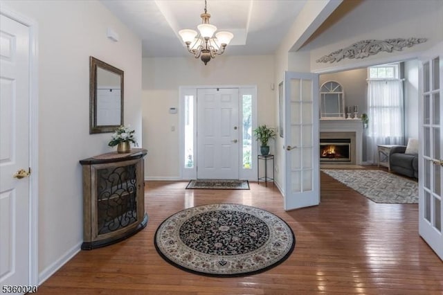 22 Troon Dr, Fredon Twp, NJ 07860 - foyer featuring wood-type flooring, a chandelier, baseboards, and a warm lit fireplace