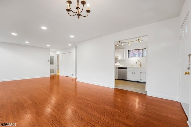 101 River Rd Unit C2, Nutley Twp, NJ 07110 - unfurnished living room featuring a chandelier, recessed lighting, light wood-type flooring, baseboards, and a sink
