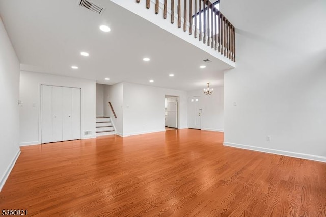 101 River Rd Unit C2, Nutley Twp, NJ 07110 - unfurnished living room with stairway, baseboards, recessed lighting, light wood finished floors, and a chandelier
