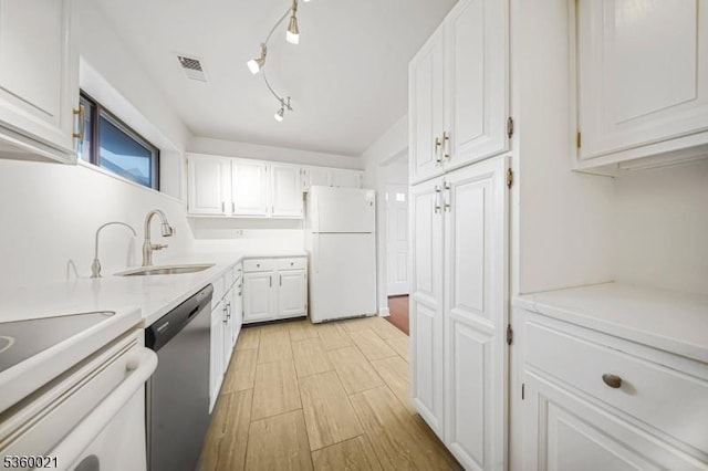 101 River Rd Unit C2, Nutley Twp, NJ 07110 - kitchen featuring freestanding refrigerator, stainless steel dishwasher, a sink, white cabinets, and light countertops