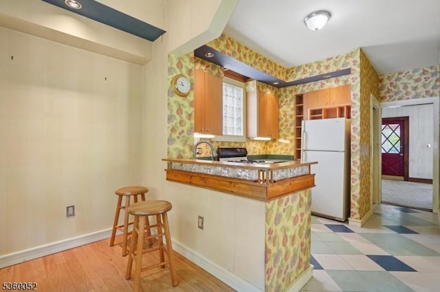 139 S Maple Ave, Springfield Twp, NJ 07081 - kitchen featuring freestanding refrigerator, wallpapered walls, a peninsula, baseboards, and a sink