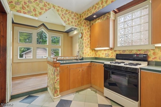 139 S Maple Ave, Springfield Twp, NJ 07081 - kitchen with gas range, a peninsula, plenty of natural light, wallpapered walls, and a sink