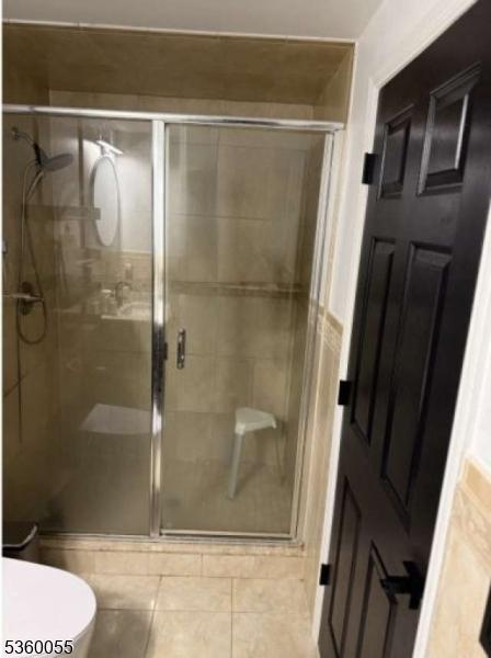 284 W Webster Ave, Roselle Park Boro, NJ 07204 - bathroom featuring a shower stall, toilet, and tile patterned flooring