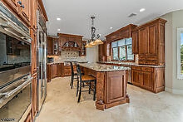 2 Kristina Way, Raritan Twp, NJ 08822 - kitchen featuring brown cabinetry, a breakfast bar area, pendant lighting, a center island, and backsplash