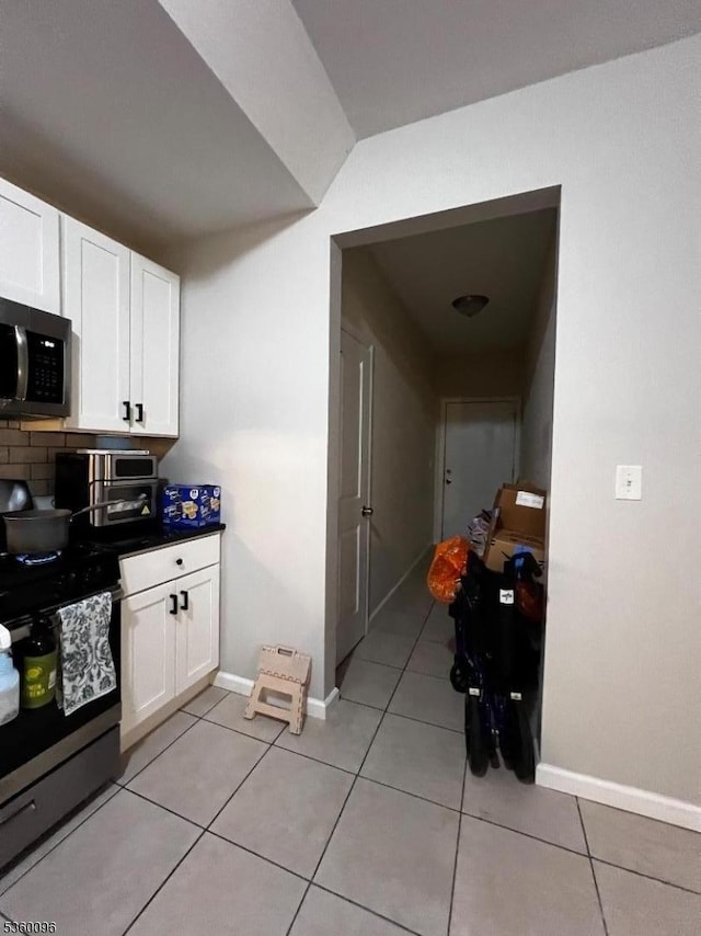 85 Tillinghast St, Newark City, NJ 07108 - kitchen featuring stainless steel appliances, white cabinets, light tile patterned floors, and baseboards