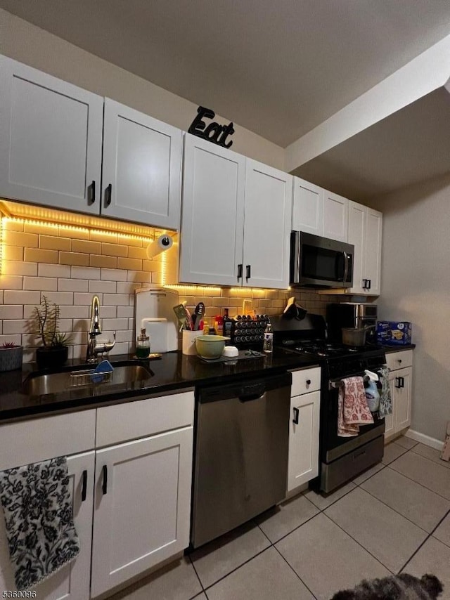 85 Tillinghast St, Newark City, NJ 07108 - kitchen featuring appliances with stainless steel finishes, a sink, tasteful backsplash, dark countertops, and light tile patterned flooring