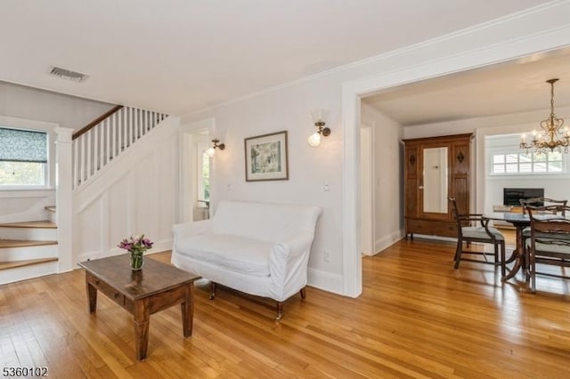 405 High St, Cranford Twp, NJ 07016 - living room with light wood-type flooring, a chandelier, stairs, and crown molding