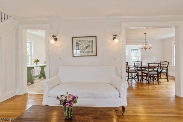 405 High St, Cranford Twp, NJ 07016 - living area featuring light wood finished floors, plenty of natural light, a chandelier, baseboards, and crown molding