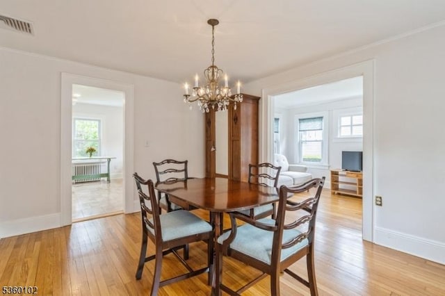 405 High St, Cranford Twp, NJ 07016 - dining area featuring radiator, a chandelier, light wood-style flooring, and baseboards