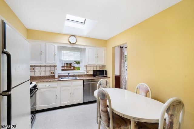 54 Pitman Rd, Parsippany-Troy Hills Twp, NJ 07054 - kitchen featuring appliances with stainless steel finishes, a sink, a skylight, white cabinetry, and light floors