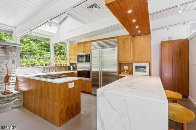 63 Hollow Brook Rd, Tewksbury Twp, NJ 07830 - kitchen featuring built in appliances, a peninsula, a skylight, beamed ceiling, and track lighting