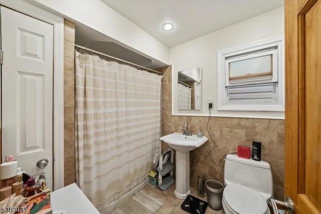 100 N 8th St, Paterson City, NJ 07522 - bathroom with tile patterned floors, tile walls, toilet, curtained shower, and a sink