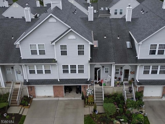 182 Durham Ct, Independence Twp, NJ 07840 - view of property with stairs, concrete driveway, brick siding, an attached garage, and roof with shingles