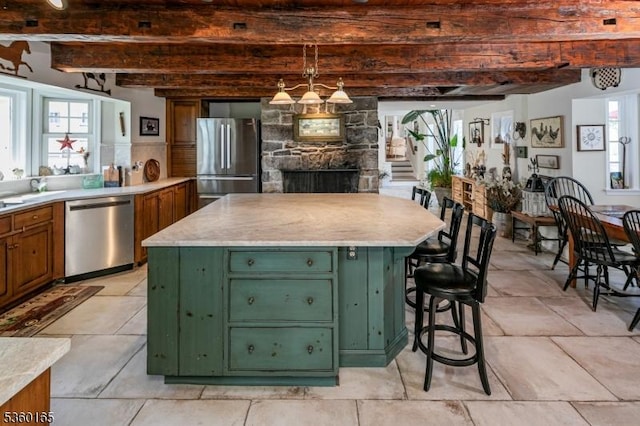 760 Rosemont Ringoes Rd, Delaware Twp, NJ 08559 - kitchen with green cabinets, stainless steel appliances, beam ceiling, light countertops, and a stone fireplace