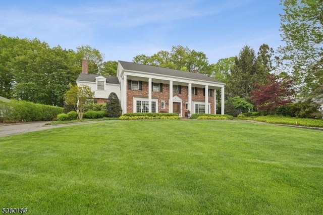 70 Falmouth St, Millburn Twp, NJ 07078 - neoclassical / greek revival house with a front yard, brick siding, and a chimney