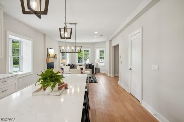 603 Springfield Ave Unit 104, Summit City, NJ 07901 - kitchen featuring light countertops, light wood-style floors, hanging light fixtures, open floor plan, and white cabinetry