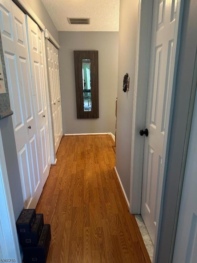 8 Bristol Dr, North Brunswick Twp, NJ 08902 - hallway with light wood finished floors, baseboards, and a textured ceiling