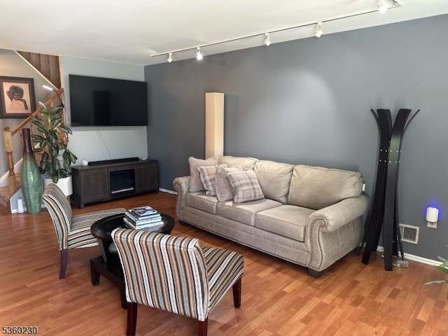 8 Bristol Dr, North Brunswick Twp, NJ 08902 - living room with rail lighting, light wood-style flooring, baseboards, and stairs