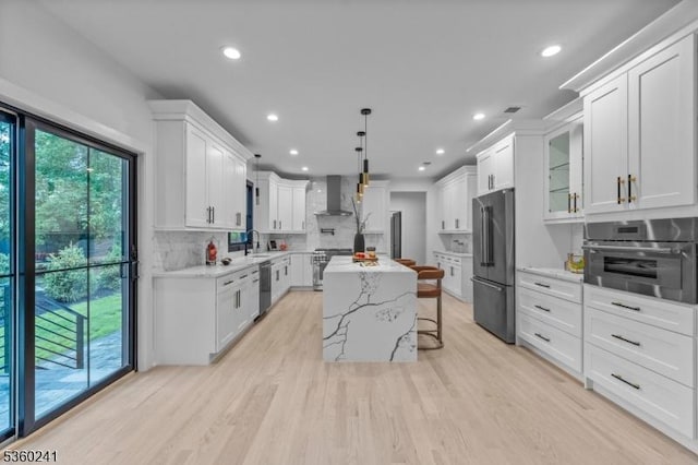 10 Wilson Ave, Wayne Twp, NJ 07470 - kitchen with premium appliances, wall chimney range hood, tasteful backsplash, a center island, and white cabinetry