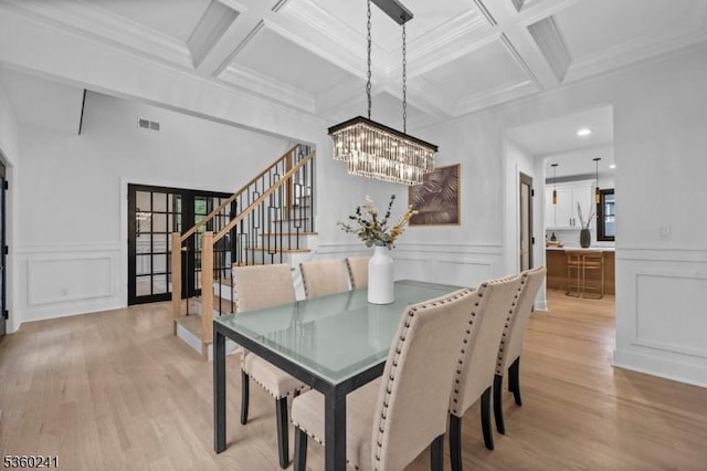 10 Wilson Ave, Wayne Twp, NJ 07470 - dining space featuring stairway, a chandelier, a decorative wall, light wood-style flooring, and beamed ceiling