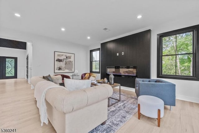 10 Wilson Ave, Wayne Twp, NJ 07470 - living area featuring light wood finished floors, healthy amount of natural light, recessed lighting, and a glass covered fireplace