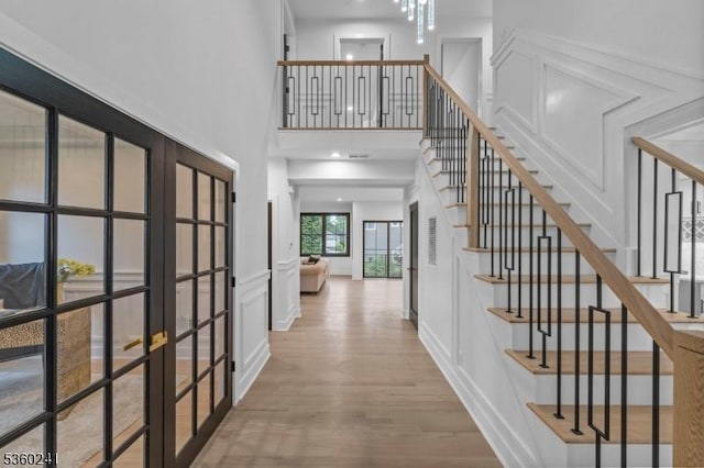 10 Wilson Ave, Wayne Twp, NJ 07470 - stairs with a decorative wall, french doors, wood finished floors, and a high ceiling