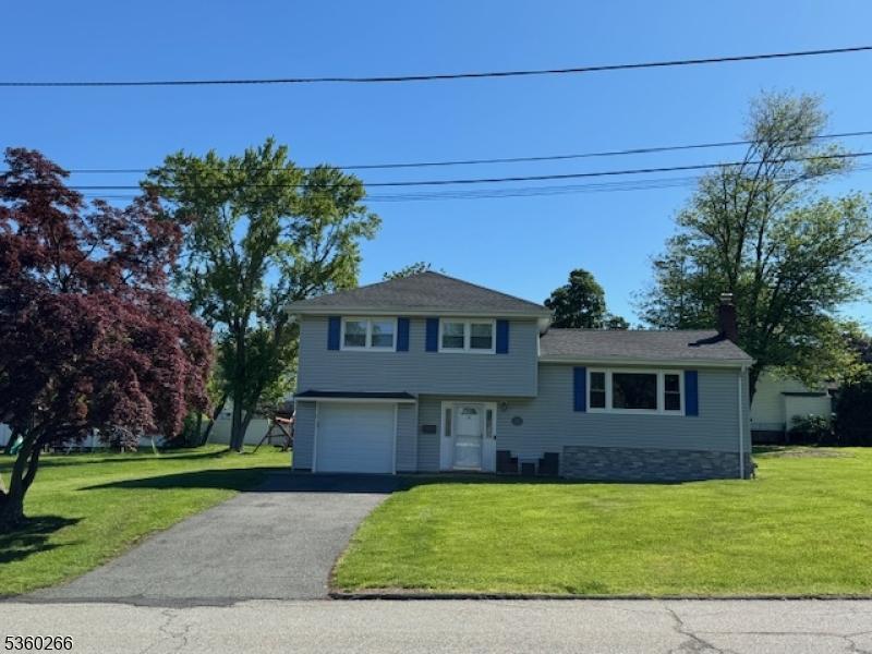 74 Knickerbocker Ave, Randolph Twp, NJ 07869 - split level home featuring an attached garage, a front lawn, asphalt driveway, and a chimney