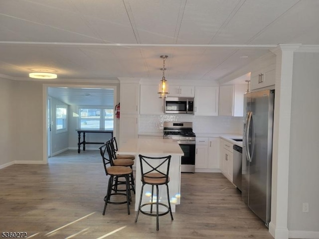 131 Douglas Dr, Jackson Twp, NJ 08527 - kitchen featuring stainless steel appliances, a kitchen bar, backsplash, white cabinets, and light wood-type flooring