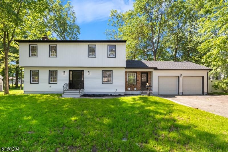 17 New England Dr, Parsippany-Troy Hills Twp, NJ 07034 - colonial-style house featuring an attached garage, a front lawn, and driveway