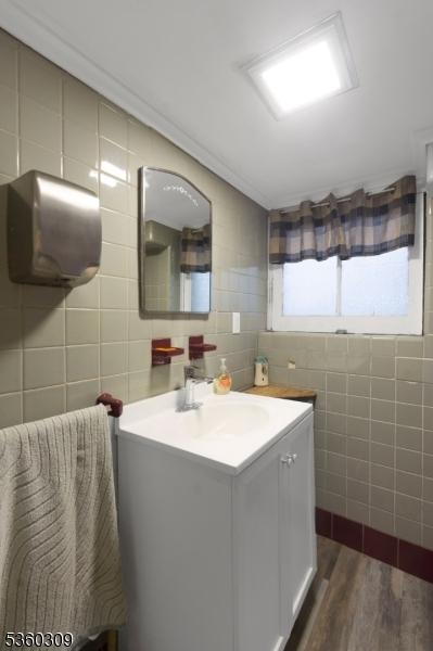 36 William St, West Orange Twp, NJ 07052 - bathroom with tile walls, vanity, and wood finished floors