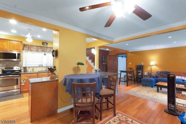 36 William St, West Orange Twp, NJ 07052 - kitchen with stainless steel appliances, light wood-style floors, ceiling fan, a sink, and ornamental molding