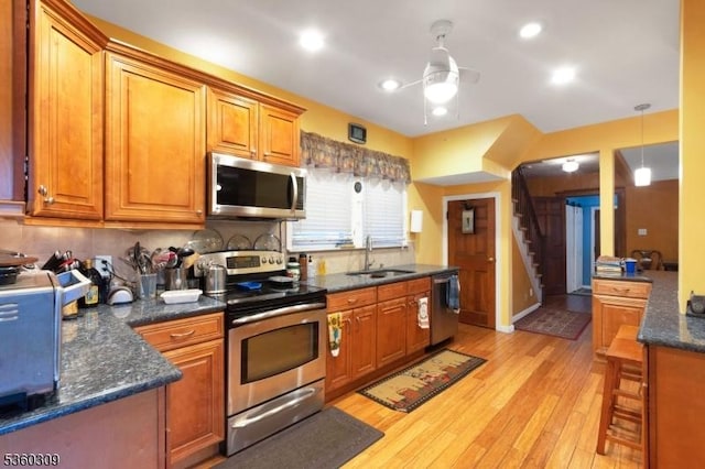 36 William St, West Orange Twp, NJ 07052 - kitchen featuring appliances with stainless steel finishes, a sink, ceiling fan, light wood-type flooring, and decorative backsplash