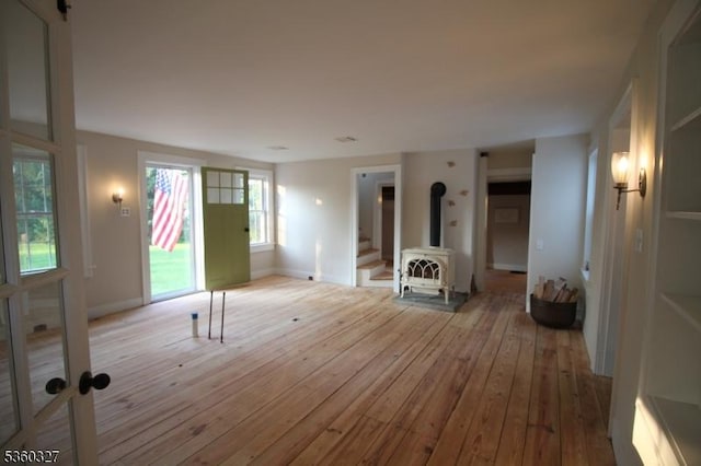 89 Leffler Hill Rd, Raritan Twp, NJ 08822 - unfurnished living room featuring wood-type flooring, a wood stove, and stairway
