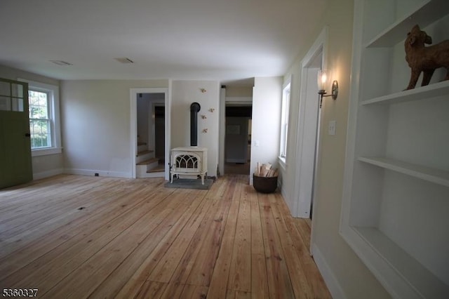 89 Leffler Hill Rd, Raritan Twp, NJ 08822 - unfurnished living room featuring a wood stove, light wood-style flooring, and built in shelves