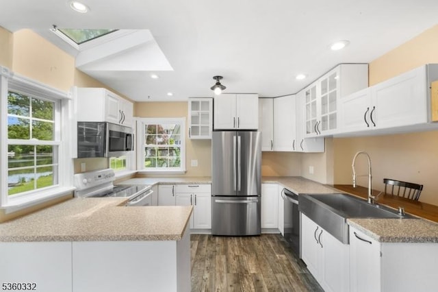 111 Lake Dr, Byram Twp, NJ 07874 - kitchen featuring stainless steel appliances, a sink, a peninsula, dark wood-type flooring, and glass insert cabinets