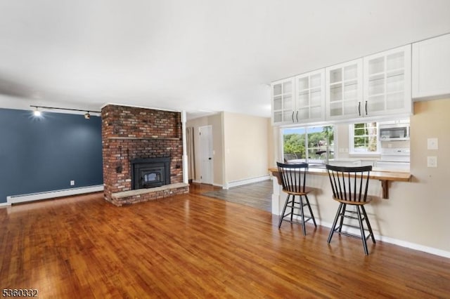 111 Lake Dr, Byram Twp, NJ 07874 - living area featuring a baseboard radiator, rail lighting, wood finished floors, and baseboards