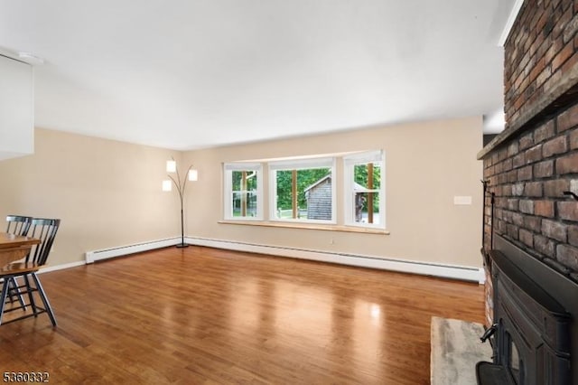 111 Lake Dr, Byram Twp, NJ 07874 - unfurnished living room featuring a wood stove, baseboard heating, wood finished floors, and a baseboard radiator