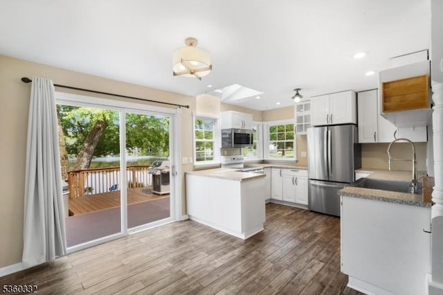 111 Lake Dr, Byram Twp, NJ 07874 - kitchen with stainless steel appliances, a sink, white cabinets, dark wood-type flooring, and a peninsula