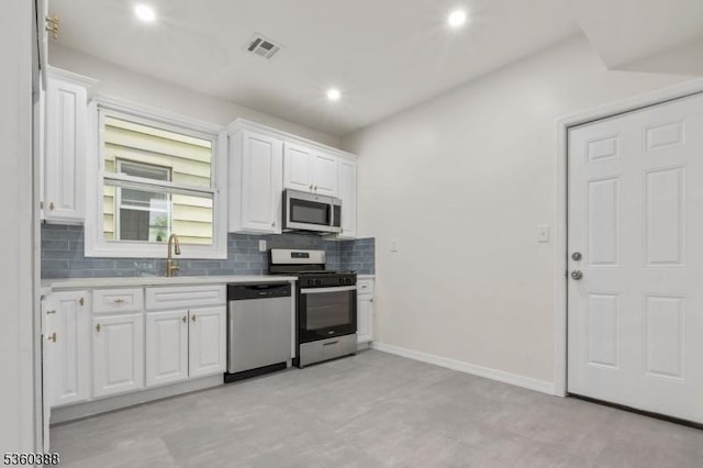 261 22nd St, Irvington Twp, NJ 07111 - kitchen featuring appliances with stainless steel finishes, a sink, backsplash, light countertops, and white cabinetry