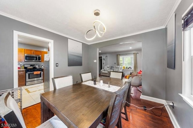 896 Maurice Ave, Rahway City, NJ 07065 - dining space with ornamental molding, wood finished floors, baseboards, arched walkways, and a chandelier