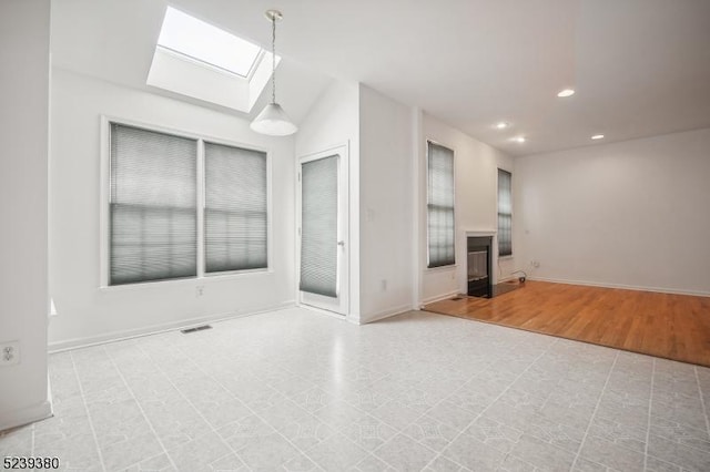 12 Hudson Dr, Bernards Twp, NJ 07920 - unfurnished living room with a skylight, a glass covered fireplace, recessed lighting, and baseboards