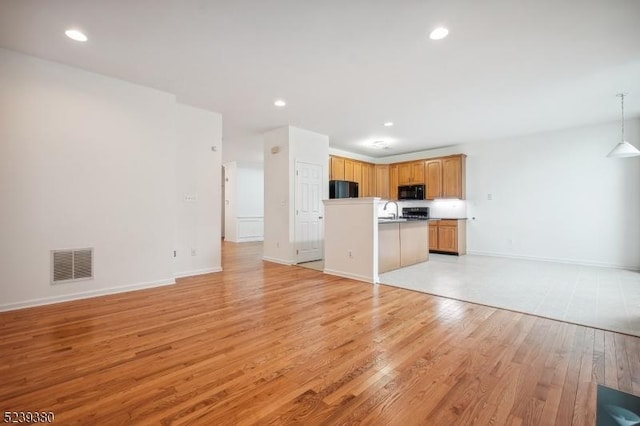 12 Hudson Dr, Bernards Twp, NJ 07920 - unfurnished living room featuring light wood-style floors, a sink, recessed lighting, and baseboards