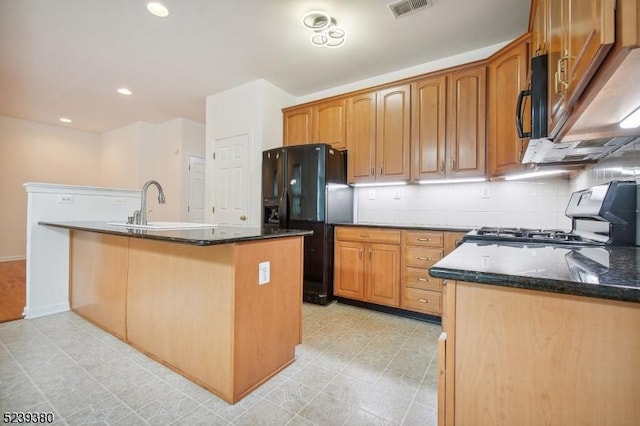 12 Hudson Dr, Bernards Twp, NJ 07920 - kitchen featuring black appliances, a sink, dark stone counters, backsplash, and an island with sink