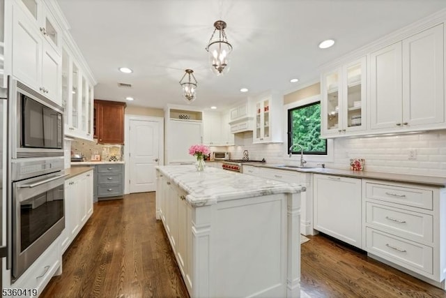 325 Hobar Ct, Franklin Lakes Boro, NJ 07417 - kitchen featuring appliances with stainless steel finishes, decorative backsplash, a sink, a center island, and dark wood-type flooring